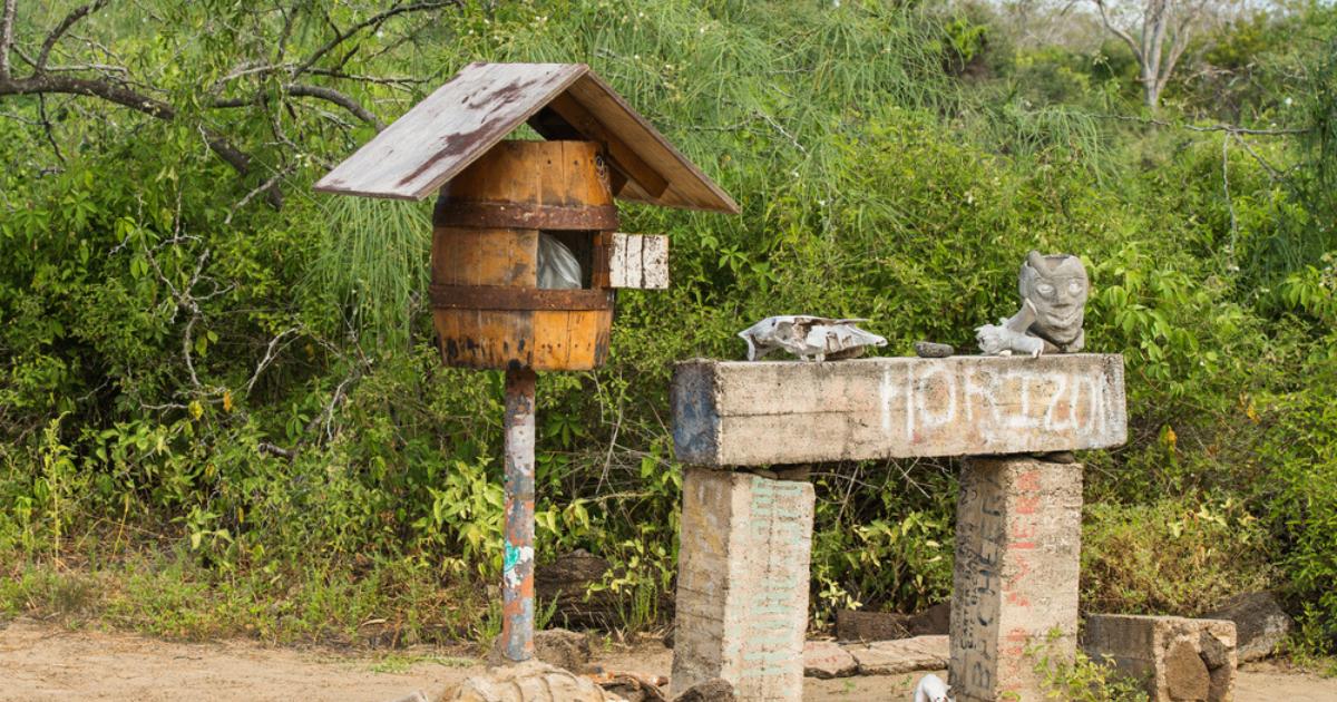 Barrel mailbox and lush green landscape on Post Office Bay, on the Galapagos island of Floreana